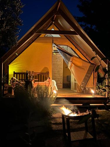 a tent with a table in front of it at night at GLAMPING SUITE IL GRILLO in Lamporecchio