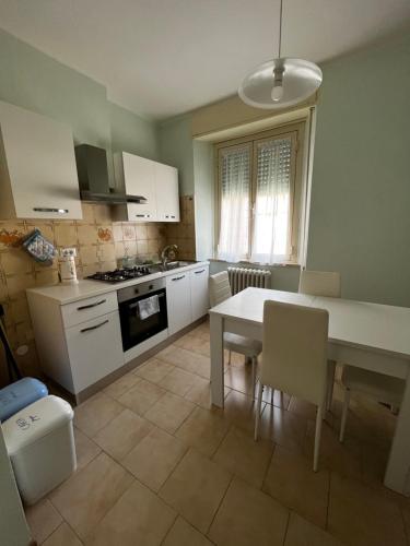 a kitchen with a white table and a table and chairs at Il Balconcino su Spello in Spello