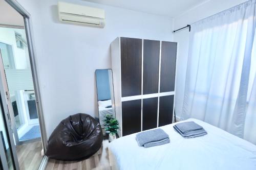 a bedroom with a mirror and a bed and a chair at 7min BKK airport - free pick up - malls nearby in Bangkok
