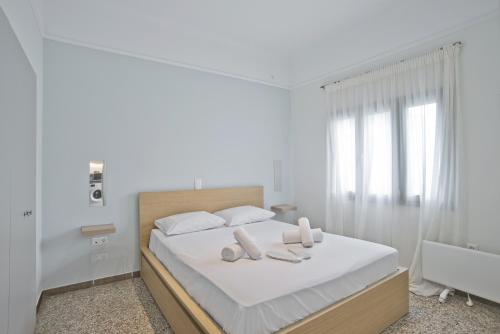 een witte slaapkamer met een bed met twee handdoeken erop bij Athina in Athene