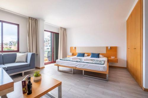 een hotelkamer met een bed, een bank en een tafel bij Sarah's Apartment by GALMI in Caniço