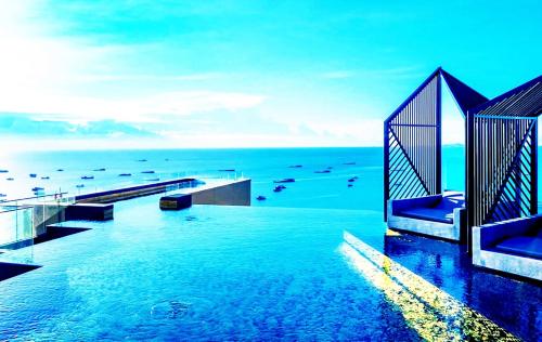 a swimming pool with the ocean in the background at The Edge Central Infinity in Pattaya