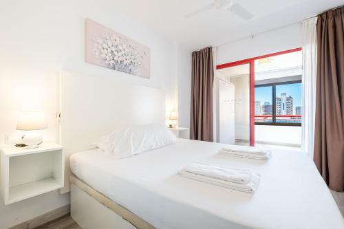 - une chambre blanche avec un lit blanc et une fenêtre dans l'établissement Loix Mar 11-E Apartment Levante Beach, à Benidorm