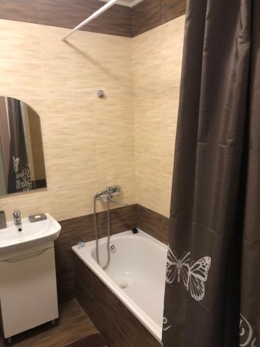 ein Badezimmer mit einer Badewanne und einem Waschbecken in der Unterkunft Квартира по вулиці Набережна in Wyschhorod