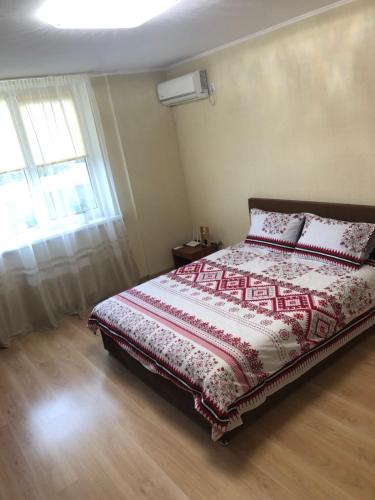 1 dormitorio con cama y ventana en Квартира по вулиці Набережна, en Vyshgorod