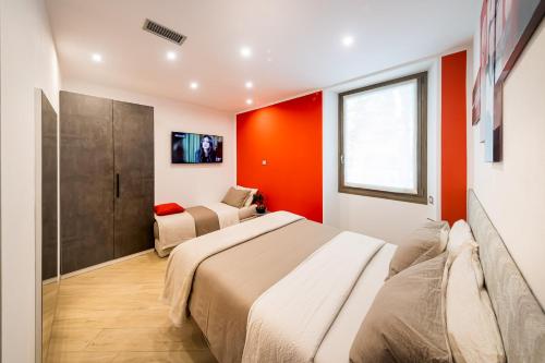 a bedroom with two beds and red walls at Luna Nuova in Tirano