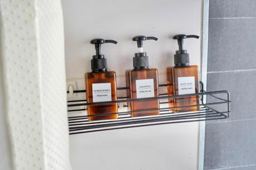 four bottles of soap on a shelf in a bathroom at 7min BKK airport - free pick up - malls nearby in Bangkok