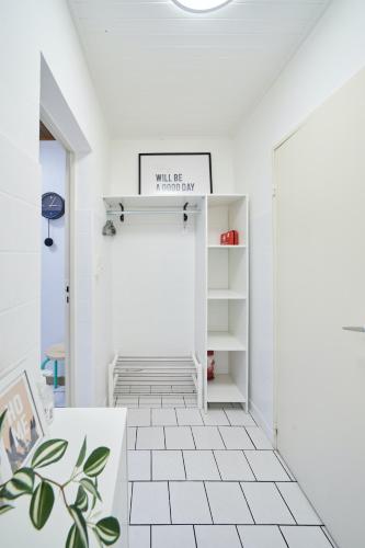 - un couloir blanc avec du carrelage blanc dans l'établissement L'Alsacien Zen, à Mulhouse