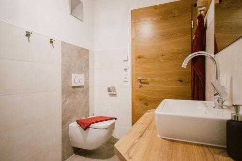 un bagno con un lavandino bianco e un water di Nedererhof - Zimmer Edelweiß mit Gemeinschaftsküche a Schmirn