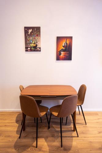 a dining room table with chairs in front of a wall at New Gudauri Luxury Studio in Gudauri