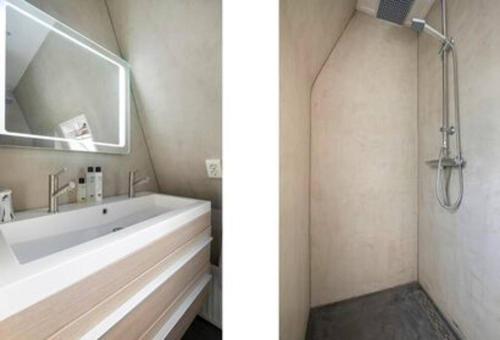 een badkamer met een groot wit bad en een spiegel bij Een heerlijke woning op loopafstand van centrum! in Leeuwarden