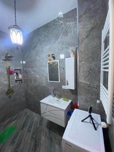 La salle de bains est pourvue d'un lavabo et d'un miroir. dans l'établissement My sweet home in Rustavi city 1, à Roustavi