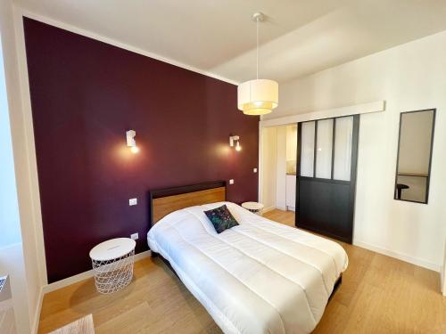 a bedroom with a large bed and a purple wall at LE CARREAU DE FALGUIERE - Hypercentre - Gare in Toulouse