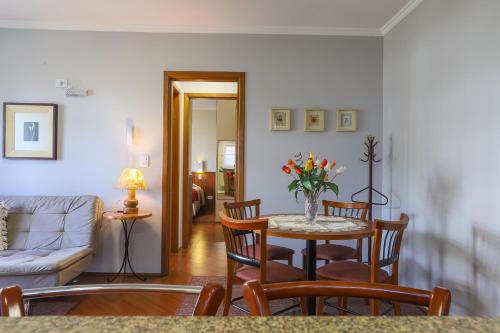 a living room with a table and chairs and a couch at Hotel Palazzo Reale in Campos do Jordão