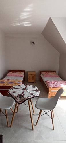 a room with two beds and a table and chairs at Willa Gorce in Ostrowsko
