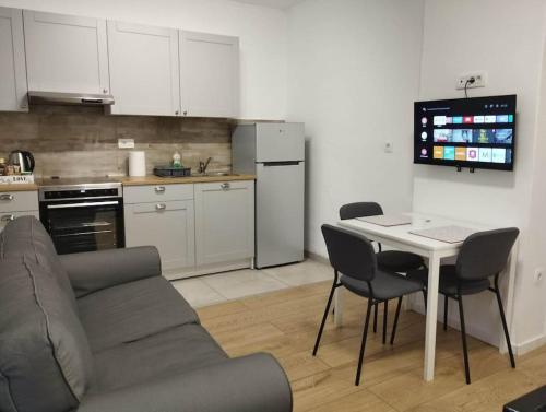 a kitchen with a couch and a table with chairs at Lovely flat, city center with free parking in Varaždin