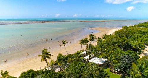 an aerial view of a beach with palm trees and the ocean at POUSADA DAS FLORES in Porto Seguro