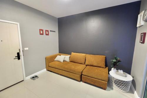 a living room with a brown couch in a room at 7min BKK airport - free pick up - malls nearby in Bangkok