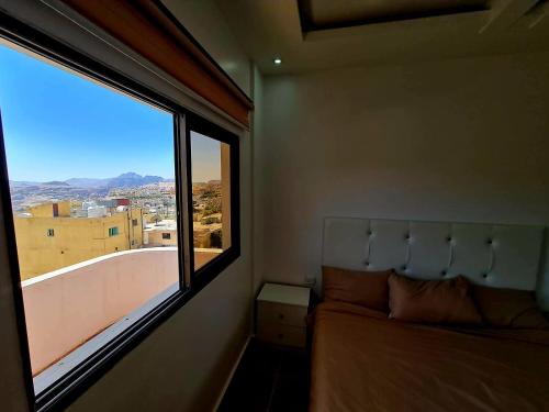 瓦迪穆薩的住宿－Petra Sunset Bed & Breakfast，一间卧室设有一张床和一个大窗户
