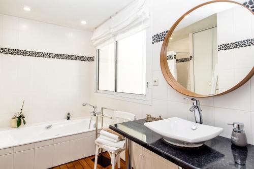 uma casa de banho com um lavatório e um espelho em Chambre d'Hôtes de la Grande Greve em Roscoff