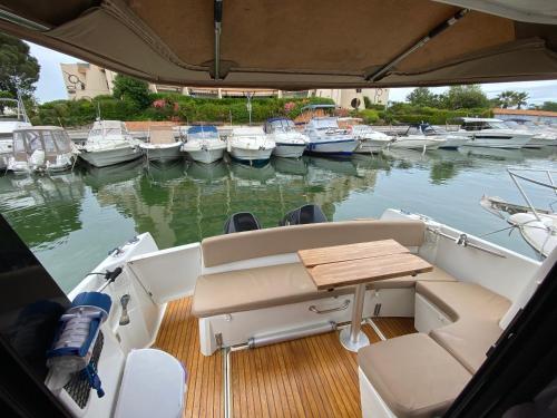 łódź ze stołem i łodzie w wodzie w obiekcie Séjour sur bateau de plaisance w mieście Mandelieu-la-Napoule