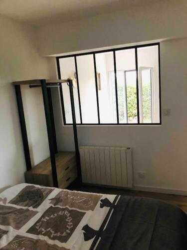 Ένα ή περισσότερα κρεβάτια σε δωμάτιο στο Maisonnette avec terrasse
