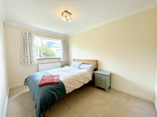 um pequeno quarto com uma cama e uma janela em 3 Chatsworth Road, Worsley em Manchester