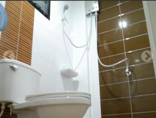 a bathroom with a toilet and a shower with a hose at Dhub Hostel Donmueng in Bangkok