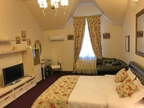 um quarto de hotel com uma cama e uma televisão em Vila Green Park em Chisinau