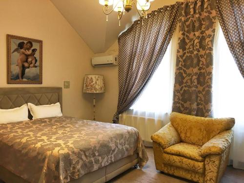 um quarto com uma cama, uma cadeira e uma janela em Vila Green Park em Chisinau