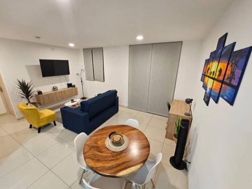 a living room with a table and a blue couch at Charming Retreat Heredia: Your Home Away from Home in Heredia