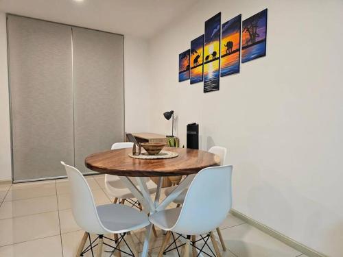 a dining room with a wooden table and white chairs at Charming Retreat Heredia: Your Home Away from Home in Heredia