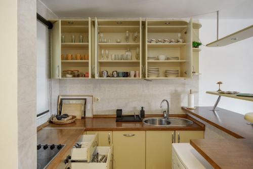 una cocina con armarios amarillos y fregadero en The Greens Family House en Zlatibor