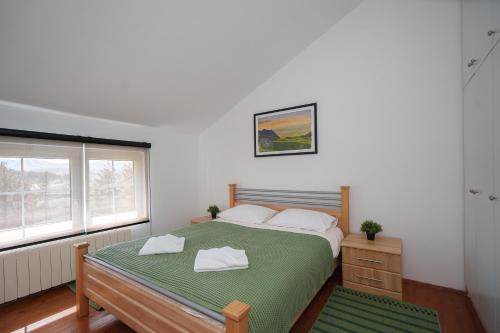 a bedroom with a large bed and a window at The Greens Family House in Zlatibor