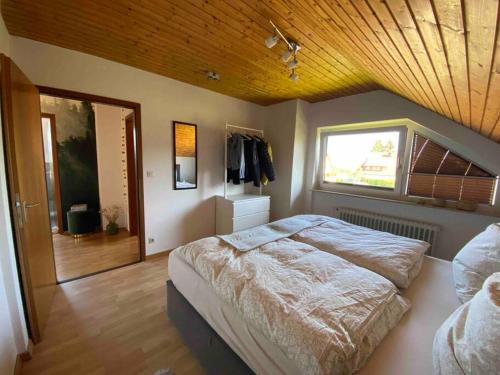 ein Schlafzimmer mit einem großen Bett und einer Holzdecke in der Unterkunft Ruhige Wohnung im Schwarzwald in Villingen-Schwenningen