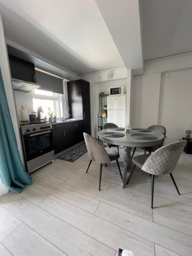a kitchen and dining room with a table and chairs at Welcome to Bucharest Airport Residences & Therme-SELF CHECK-IN in Otopeni