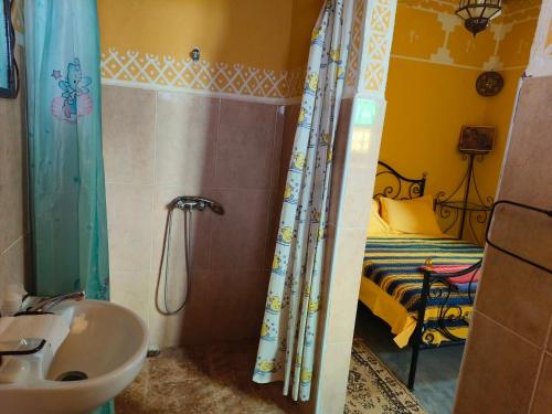 La salle de bains est pourvue d'un lavabo et d'un lit dans la chambre. dans l'établissement Kasbah Imini Restaurant & Hotel, à Taourirt