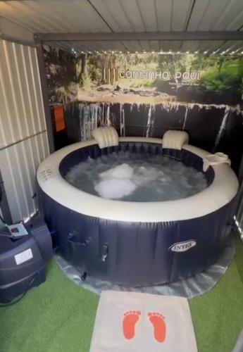 a jacuzzi tub in a tent with two chairs at Cantinho Do Paul in Arouca