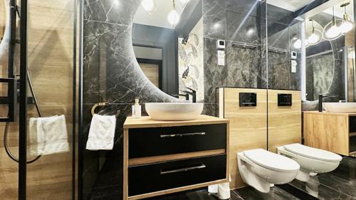 a bathroom with a sink and a toilet and a shower at Przytulny elegancki APARTAMENT przy dworcu in Elblag
