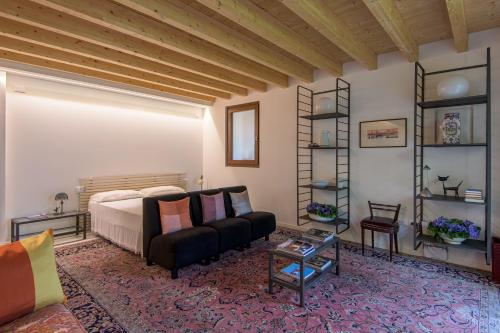 a bedroom with a bed and a couch and a table at In Riva al Lago di Iseo Dependance Piano Terra in Marone