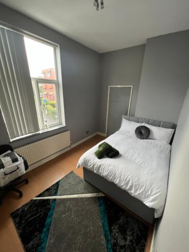 a bedroom with a bed with two pillows and a window at CENTRAL BIRMINGHAM 3 Bedroom 3 Bed Apartment in Birmingham