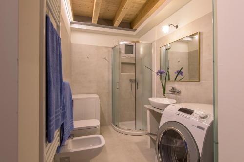 La salle de bains est pourvue d'un lave-linge et d'un lave-linge. dans l'établissement Dependance In Riva al Lago Piano Terra, à Marone