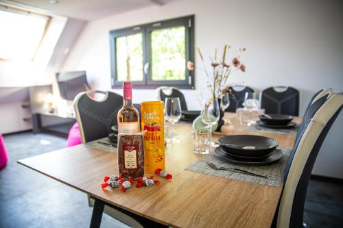 einen Holztisch mit zwei Flaschen Wein darauf in der Unterkunft Bienvenue dans le violine 2 à 6 couchages in Cholonge