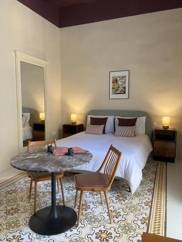 a bedroom with a large bed with a table and chairs at Birgu No 25 apartment 2 in Birgu