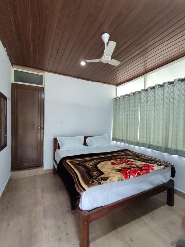 a bedroom with a bed with a ceiling fan at Lovely Home Stay Munnar in Munnar