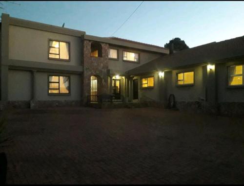 a large house with its lights on in the night at Jewel of Jozi in Edenvale