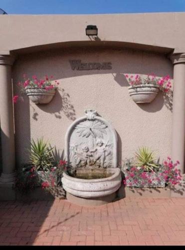 a fountain in front of a building with flowers at Jewel of Jozi in Edenvale