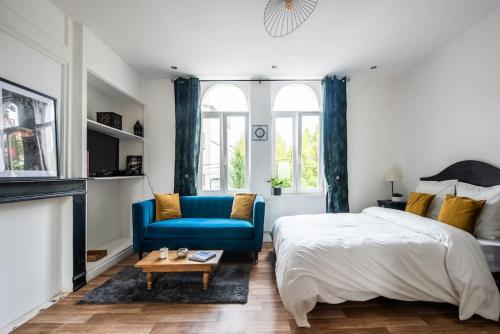 um quarto com uma cama e uma cadeira azul em Appartement Lumineux et cozy à LILLE Lomme em Lille