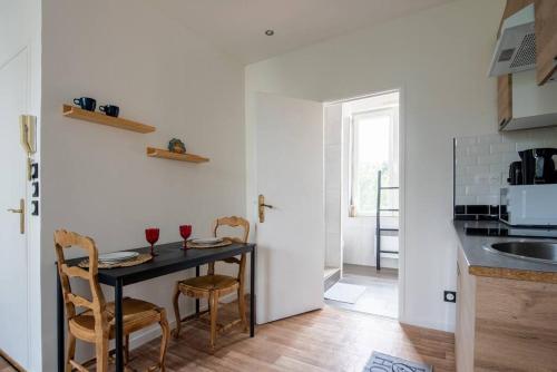a kitchen with a table with two glasses of wine at Appartement Lumineux et cozy à LILLE Lomme in Lille