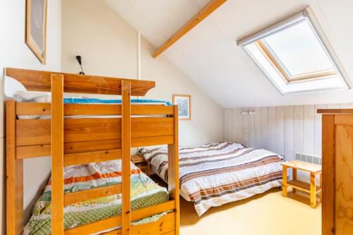a bedroom with two bunk beds in a attic at Superbe et chaleureux gîte familial in Beauraing